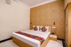 um quarto com uma cama grande e almofadas coloridas em FabHotel Heritage Palace em Aurangabad