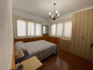 1 dormitorio con cama y lámpara de araña en Casa Cal Duc, la Garriga, en La Garriga