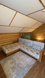 - un grand lit dans une chambre dotée de murs en bois dans l'établissement Гостевой дом ЧИСТЫЕ ПРУДЫ, à Koshi