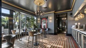 a dining room with a bar with chairs and a chandelier at The Riversleigh in Bairnsdale