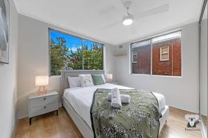 Un dormitorio con una cama grande y una ventana en KozyGuru / Clovelly / 2B Kozy APT / NCL037 en Sídney
