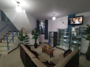 a living room with a couch and a tv at Hostal Puerto Ingles in Ilo
