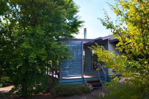 a blue house with a porch and stairs at Eastern View Villa in Daylesford
