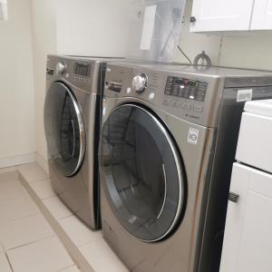 two washing machines sitting next to each other in a kitchen at toronto midtown spacious room in Toronto