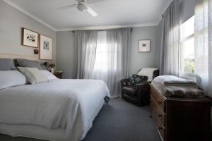 a bedroom with a bed and a chair and a window at Ebony Twigg in Hepburn Springs