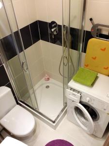 a bathroom with a shower and a washing machine at Apartamenty Słupsk in Słupsk