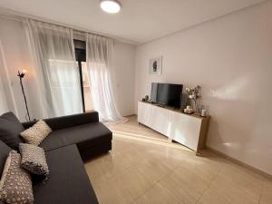 - un salon avec un canapé et une télévision dans l'établissement Altamira 1 Campello piscina, garaje ,wifi, A/C, à El Campello
