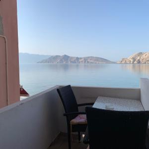a balcony with a table and chairs and a view of the water at Marija Seršić “Narca” in Baška