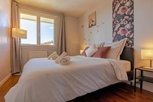 1 dormitorio con 1 cama blanca grande y ventana en L'échappee du 36 - 4 chambres dans le Triangle d'Or à 100m du lac, parking gratuit, en Annecy