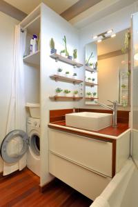 une salle de bain avec un lavabo et une machine à laver dans l'établissement L'échappee du 36 - 4 chambres dans le Triangle d'Or à 100m du lac, parking gratuit, à Annecy 66 autres photos