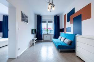 a living room with a blue couch and a window at Blue Apartment Browar Central in Poznań