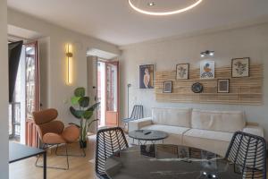 a living room with a couch and a table and chairs at Aparthotel ARDMADRID Centro in Madrid