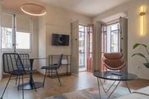 un soggiorno con tavolo e sedie di Aparthotel ARDMADRID Centro a Madrid