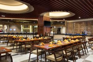 un ristorante con tavoli e sedie in legno e un bar di Panbil Residence Serviced Apartment a Batam Center