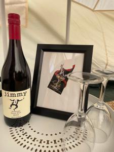 eine Flasche Wein und zwei Gläser auf dem Tisch in der Unterkunft Cosy Glamping Tent 2 in Ararat