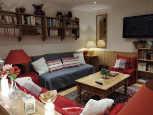 een woonkamer met een bank en een tafel bij Hotel La Source in La Foux