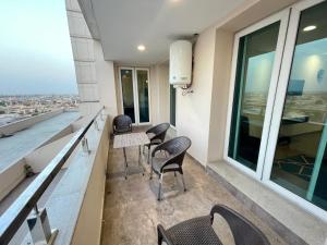 拉合爾的住宿－AirReside Hotel Apartments Gold Crest，阳台,带椅子和桌子