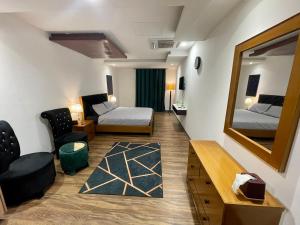 a hotel room with two beds and a mirror at AirReside Hotel Apartments Gold Crest in Lahore
