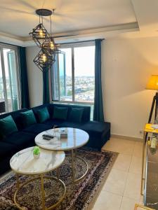 een woonkamer met een blauwe bank en een tafel bij AirReside Hotel Apartments Gold Crest in Lahore