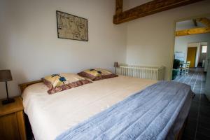 een slaapkamer met een groot wit bed met 2 kussens bij La Créquoise 