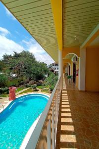 - une piscine à côté d'une maison avec terrasse couverte dans l'établissement Hanbee's Resort, à Puerto Princesa