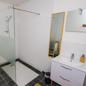 een badkamer met een wastafel en een glazen douche bij La Créquoise 