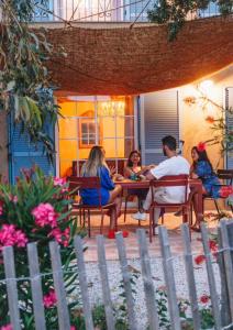 een groep mensen die aan een tafel zitten bij Residence CASE DI PI GNA, deux magnifiques villas indépendantes avec piscines individuelles , proches de la plage d'Algajola in Algajola