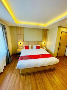 a large bedroom with a large bed with red pillows at Hotel Aerocity in Kathmandu