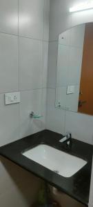 La salle de bains est pourvue d'un lavabo et d'un miroir. dans l'établissement Luxurious Apartment with a pool and gym near Trivandrum railway station, à Trivandrum