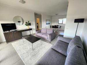 a living room with a couch and a tv at Oceanic on Thompson Apartments in Cowes