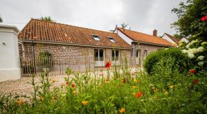 a house with a garden with flowers in front of it at La Créquoise 