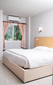 1 dormitorio blanco con 1 cama blanca grande y ventana en GP House Phuket Patong Beach, en Patong Beach