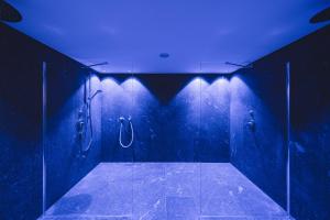 uma casa de banho escura com chuveiro e tecto azul em Hotel Lahnerhof em Vipiteno