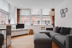 a living room with a couch and a tv at GuestReady - Northern Quarter Urban Escape in Manchester