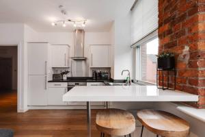a kitchen with a white counter and a brick wall at GuestReady - Northern Quarter Urban Escape in Manchester