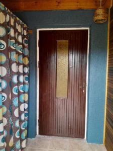 a brown door in a room with a blue wall at Irbītes in Mērsrags +2 photos
