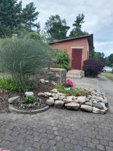a garden with rocks and flowers in front of a building at Irbītes in Mērsrags