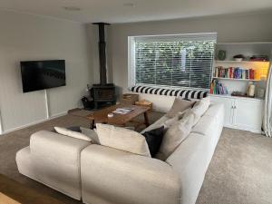 sala de estar con sofá blanco y mesa en Frankton Favourite - Queenstown Holiday Home en Queenstown