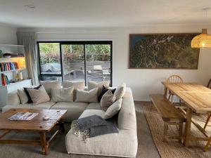 a living room with a couch and a table at Frankton Favourite - Queenstown Holiday Home in Queenstown