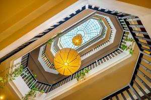 uma vista superior de uma escada em espiral com um guarda-chuva amarelo em Lantana Riverside Hoi An Boutique Hotel & Spa em Hoi An
