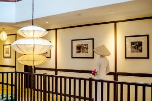 un maniquí con un traje blanco parado en una habitación con dos luces en Lantana Riverside Hoi An Boutique Hotel & Spa, en Hoi An