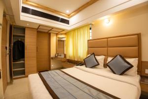 a bedroom with a large bed and a closet at Hotel Grand Sabarees in Madurai