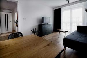 sala de estar con mesa de madera y sofá en Apartament Aura, en Biała Podlaska