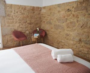 a bedroom with a bed and two chairs at HOTEL BOUTIQUE VILAVELLA in O Grove
