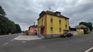 a yellow building on the side of a road at Apartmán AMSEL in Ostrov