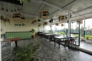 een eetkamer met tafels, stoelen en ramen bij Earth Hotels in Bangalore
