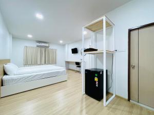 a bedroom with a bed and a desk in a room at PD Apartment Inn in Ban Pra Dok