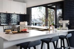 a kitchen with a counter with two stools and a sink at Fontaine in Daylesford