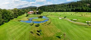 an aerial view of a golf course with a pond at Mobilheim kemp in Rožnov pod Radhoštěm