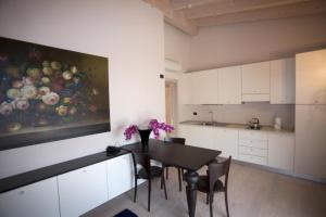 una cocina con mesa y sillas y una pintura de flores en Residence Alexandra Stay, en Sirmione